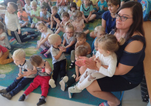 Niedźwiadki wraz z dziećmi z przedszkola z zaciekawieniem oglądające występ artysty.